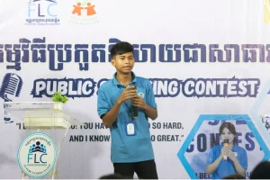 phann samet Phann Samet speaking into a microphone in front of an FLC public speaking contest banner.